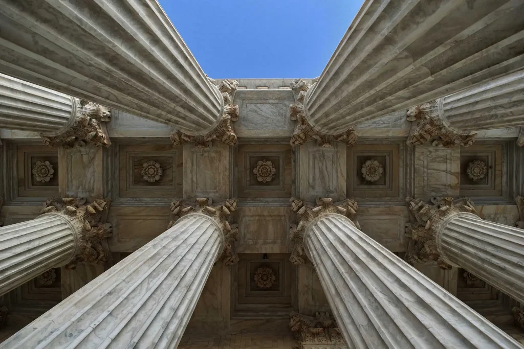 Corinthian columns and the coffered ceiling of a classical courthouse portico
